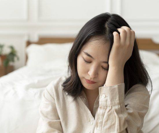 asian-woman-sitting-sad-by-her-bed-1-scaled.jpg